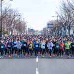 勝田全国マラソン、冬の冷たい朝にスタートを待つ大勢の日本人ランナー。大会の規模と気候条件。