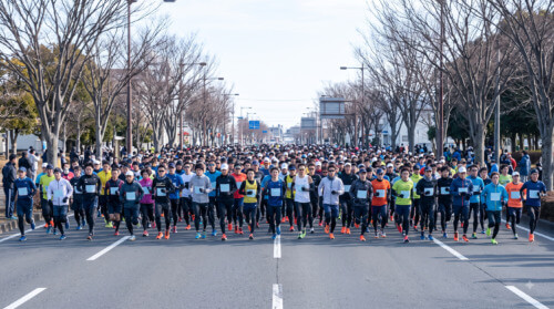 勝田全国マラソン、冬の冷たい朝にスタートを待つ大勢の日本人ランナー。大会の規模と気候条件。