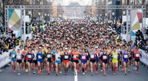 大規模な日本の市民マラソン大会のスタート地点で、大勢の日本人ランナーが密集して走り出す様子。男性ランナーが多数を占めている。