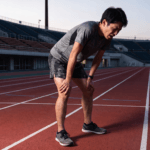 フルマラソンのトレーニングでインターバル走後に苦悶の表情で立ち止まるランナー