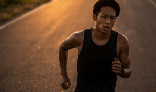 マラソンで老ける原因となる、夕暮れ時のハードトレーニングで疲労困憊の日本人男性シリアスランナー